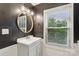 Updated bathroom with a modern vanity, round mirror and window at 407 Cherry St, Belmont, NC 28012