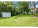Spacious backyard featuring a storage shed, mature trees, and lush green grass, perfect for outdoor activities at 435 Sixteenth St, Cramerton, NC 28032