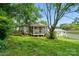 Backyard features mature trees, a lush green lawn and a screened porch at 435 Sixteenth St, Cramerton, NC 28032