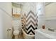 Bright bathroom with tiled floor, white cabinets, and patterned shower curtain at 435 Sixteenth St, Cramerton, NC 28032