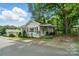 Quaint single-story home with red shutters, complemented by mature trees and a well-maintained lawn at 435 Sixteenth St, Cramerton, NC 28032