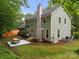 Expansive back exterior featuring a patio, with table set on a well maintained lawn and mature trees at 4848 Spicewood Dr, Charlotte, NC 28227