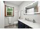Modern bathroom featuring a navy blue vanity, single sink, toilet and large light-up mirror at 4848 Spicewood Dr, Charlotte, NC 28227