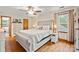 Bright bedroom features a tufted headboard bed, wood floors, ceiling fan and natural light from the windows at 4848 Spicewood Dr, Charlotte, NC 28227