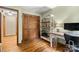 Bedroom/office combo featuring a closet, shelving, hardwood floors, and warm natural light at 4848 Spicewood Dr, Charlotte, NC 28227