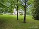 Spacious home exterior with a well-manicured lawn and mature trees at 4848 Spicewood Dr, Charlotte, NC 28227