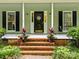 Charming front porch with brick steps, potted plants, and a decorative door sign at 4848 Spicewood Dr, Charlotte, NC 28227