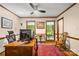 This home office features natural light from three windows, a ceiling fan, and hardwood trim at 4848 Spicewood Dr, Charlotte, NC 28227
