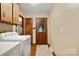 Laundry room features white appliances, wood cabinets, wood trim, and access to the backyard at 4848 Spicewood Dr, Charlotte, NC 28227