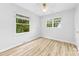 Bright bedroom with two windows, hardwood floors, and a ceiling fan at 4913 Seacroft Rd, Charlotte, NC 28210