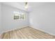 Bright, airy bedroom featuring hardwood floors, neutral walls, and a window overlooking the backyard at 4913 Seacroft Rd, Charlotte, NC 28210