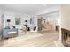Bright, open-concept living room with hardwood floors, modern fireplace, and updated kitchen access at 4913 Seacroft Rd, Charlotte, NC 28210