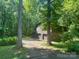 View of the barn featuring two garage bays in a lush, wooded setting at 5109 Goldcrest Dr, Indian Trail, NC 28079