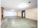 Unfinished basement featuring a brick fireplace and neutral wall paneling, ready for customization at 5109 Goldcrest Dr, Indian Trail, NC 28079