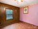 Bright bedroom with pink walls, wood-paneled accent wall, and hardwood floors at 5109 Goldcrest Dr, Indian Trail, NC 28079