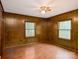 Cozy bedroom featuring wood-paneled walls, hardwood floors, and ceiling fan at 5109 Goldcrest Dr, Indian Trail, NC 28079