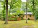 Quaint brick home nestled among mature trees and lush greenery, offering privacy and a serene setting at 5109 Goldcrest Dr, Indian Trail, NC 28079