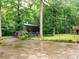View of the home surrounded by beautiful, mature trees and a wet, expansive driveway at 5109 Goldcrest Dr, Indian Trail, NC 28079