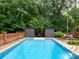 Sparkling swimming pool surrounded by lush greenery and brick fencing at 5109 Goldcrest Dr, Indian Trail, NC 28079