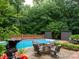 Backyard pool with mature trees and brick fence, ideal for relaxation and entertaining at 5109 Goldcrest Dr, Indian Trail, NC 28079