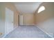 An empty bedroom with neutral paint, plush gray carpeting and a charming arched window for natural light at 5436 Scarlet Sage Dr, Charlotte, NC 28215