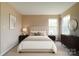 Bright bedroom featuring neutral paint, carpet floors, two large windows, and stylish decor at 5436 Scarlet Sage Dr, Charlotte, NC 28215