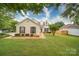 Charming one-story home with a manicured lawn and mature trees, creating a welcoming curb appeal at 5436 Scarlet Sage Dr, Charlotte, NC 28215