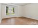 Bright bedroom features wood-look floors and a large window with pleasant view at 6203 Rosecroft Dr, Charlotte, NC 28215