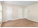 Bedroom with neutral walls and wood-look floors has multiple closets and doors at 6203 Rosecroft Dr, Charlotte, NC 28215