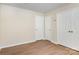 Bedroom with neutral walls and wood-look floors has multiple closets and doors at 6203 Rosecroft Dr, Charlotte, NC 28215