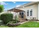 Green backyard with a covered patio and landscaping at 6303 Trevor Simpson Dr, Indian Trail, NC 28079