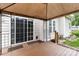 View of the covered backyard patio, sliding glass door and a small table set at 6303 Trevor Simpson Dr, Indian Trail, NC 28079