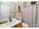 Bright bathroom features a white sink, decorative mirror and a patterned shower curtain at 6303 Trevor Simpson Dr, Indian Trail, NC 28079