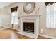 Close-up of fireplace with mantel, flanked by windows and wooden floors at 6303 Trevor Simpson Dr, Indian Trail, NC 28079
