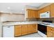 Well-lit kitchen features oak cabinets, white countertops, backsplash, and modern appliances at 6303 Trevor Simpson Dr, Indian Trail, NC 28079
