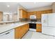 Well-lit kitchen with bright counters, wooden cabinets and modern appliances at 6303 Trevor Simpson Dr, Indian Trail, NC 28079