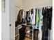 Organized closet with hanging clothes, shoe racks, and storage for personal belongings at 715 N Church St # 310, Charlotte, NC 28202