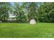 Large back yard with green grass, storage shed, and fenced in area at 798 Wilson St, China Grove, NC 28023