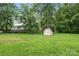 Large back yard with green grass, storage shed, and fenced in area at 798 Wilson St, China Grove, NC 28023