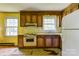 Retro kitchen featuring wooden cabinets, tile countertops, and a bright yellow wall at 798 Wilson St, China Grove, NC 28023