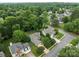 Aerial view of a neighborhood with mature trees and well-maintained homes with lush green lawns at 8906 Pickering Grove Ln, Charlotte, NC 28216