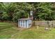 Charming backyard shed with a picket fence, surrounded by a green lawn and mature trees at 8906 Pickering Grove Ln, Charlotte, NC 28216