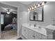 Bathroom featuring double sinks with modern fixtures and a view into the bedroom at 8906 Pickering Grove Ln, Charlotte, NC 28216