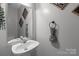 Half bath with a decorative mirror and a pedestal sink with vintage accents at 8906 Pickering Grove Ln, Charlotte, NC 28216