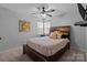 Cozy bedroom with a ceiling fan, comfortable bed, and natural light from the windows at 8906 Pickering Grove Ln, Charlotte, NC 28216