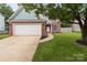 Charming single-story home with brick accents, a two-car garage, and a well-manicured front lawn at 8906 Pickering Grove Ln, Charlotte, NC 28216