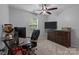 Home office with a corner desk, ceiling fan, and a large TV at 8906 Pickering Grove Ln, Charlotte, NC 28216