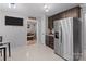 Modern kitchen with stainless steel appliances, dark cabinetry, and tile flooring at 8906 Pickering Grove Ln, Charlotte, NC 28216