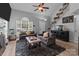 Bright living room with cozy sofas, a fireplace, large windows, and staircase access at 8906 Pickering Grove Ln, Charlotte, NC 28216