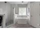 Modern bathroom featuring a glass shower, soaking tub, and stylish fixtures at 104 Edgewater Park St, Davidson, NC 28036